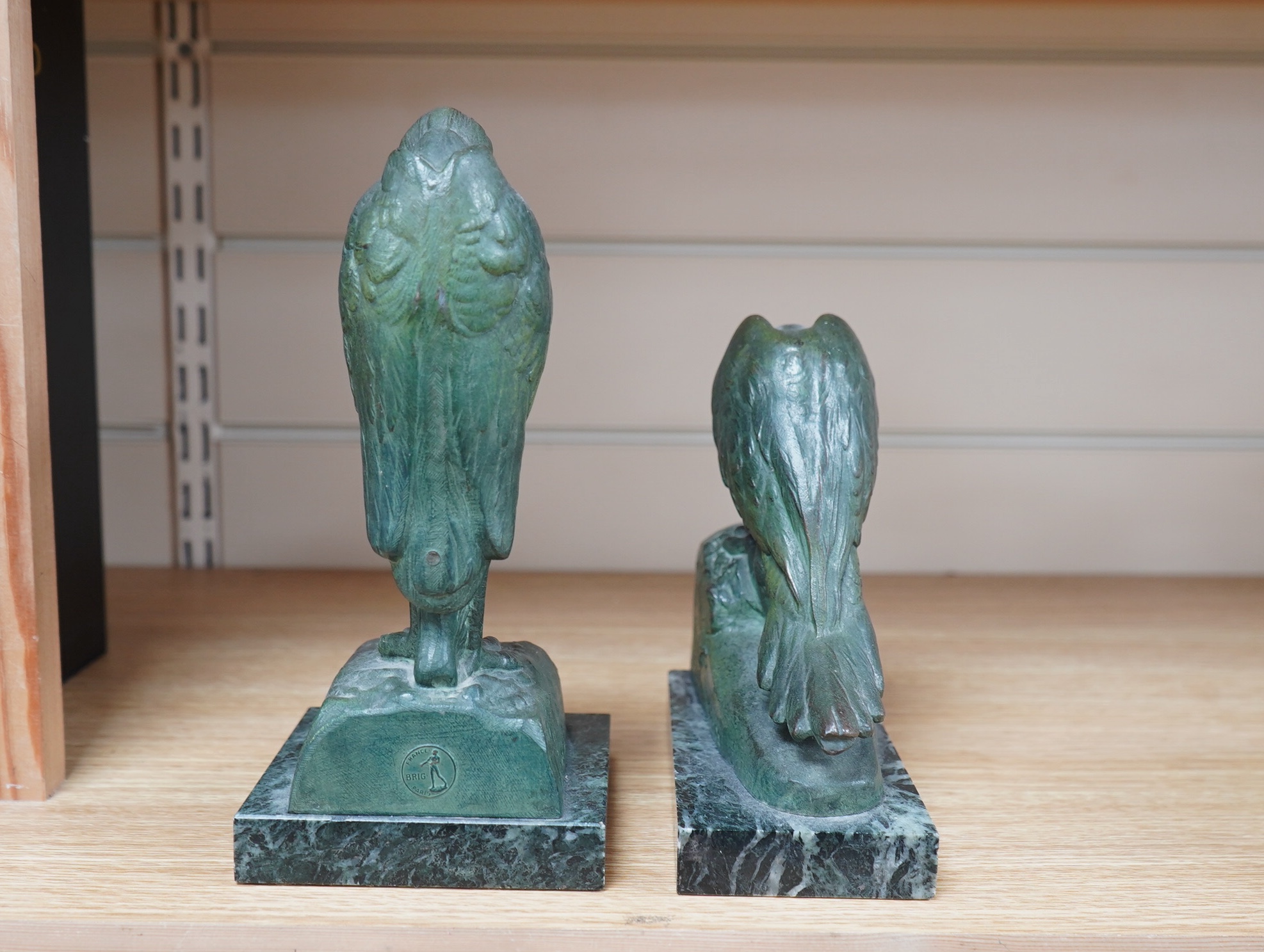 Georges Van de Voorde (Belgian 1878-1970). A pair of Art Deco bronzed spelter bookends modelled as a parrot and stork, on marble plinths, tallest 21.5cm. Condition - fair to good.